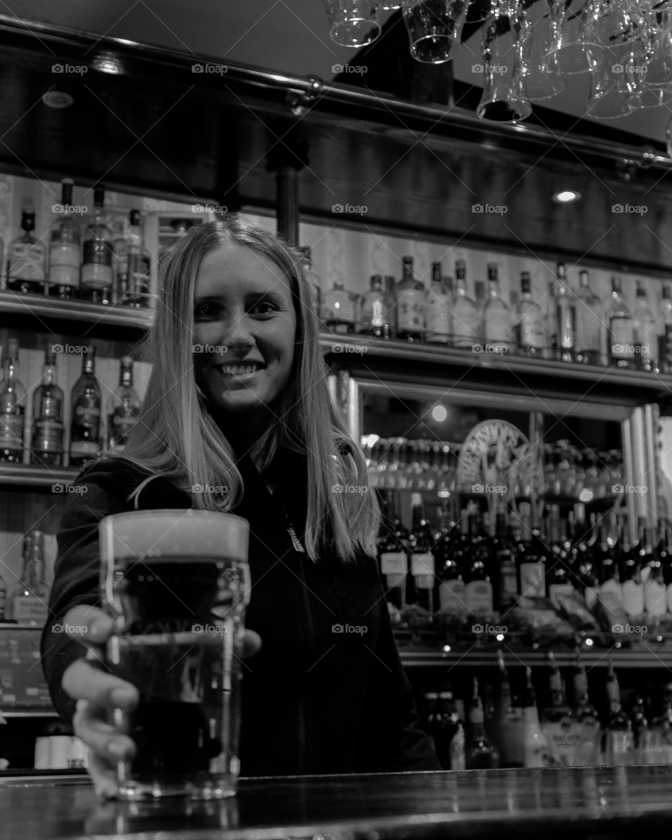 Bartender servers a pint beer glass