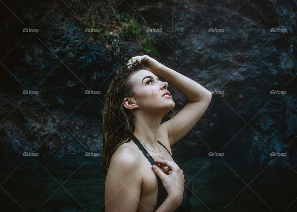 Girl coming out of the shadows in a natural hot springs 