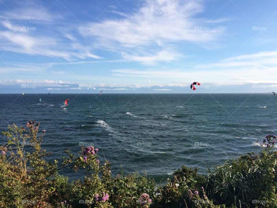 People paragliding over the sea