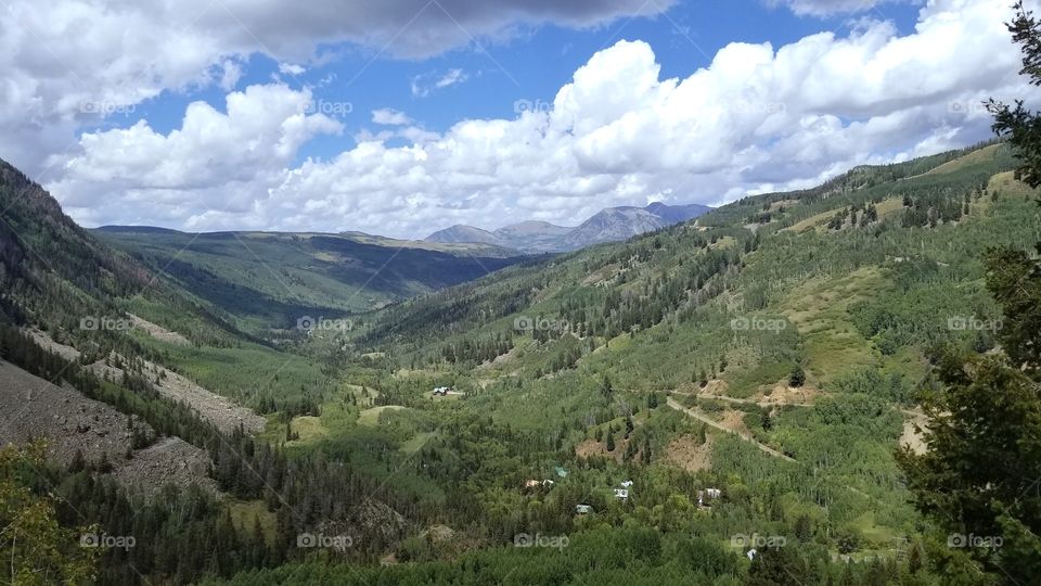 Lush, Green Colorado Rocky Mountain Valley with Puffy White Clouds