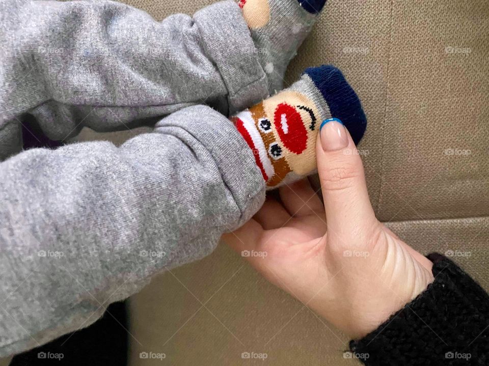 Baby’s tiny foot dressed in a Christmas sock