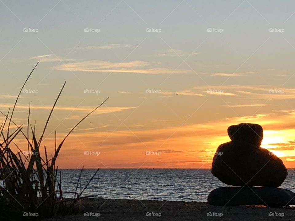 Sunset over harbor with stacked stones, wellfleet massachusettes