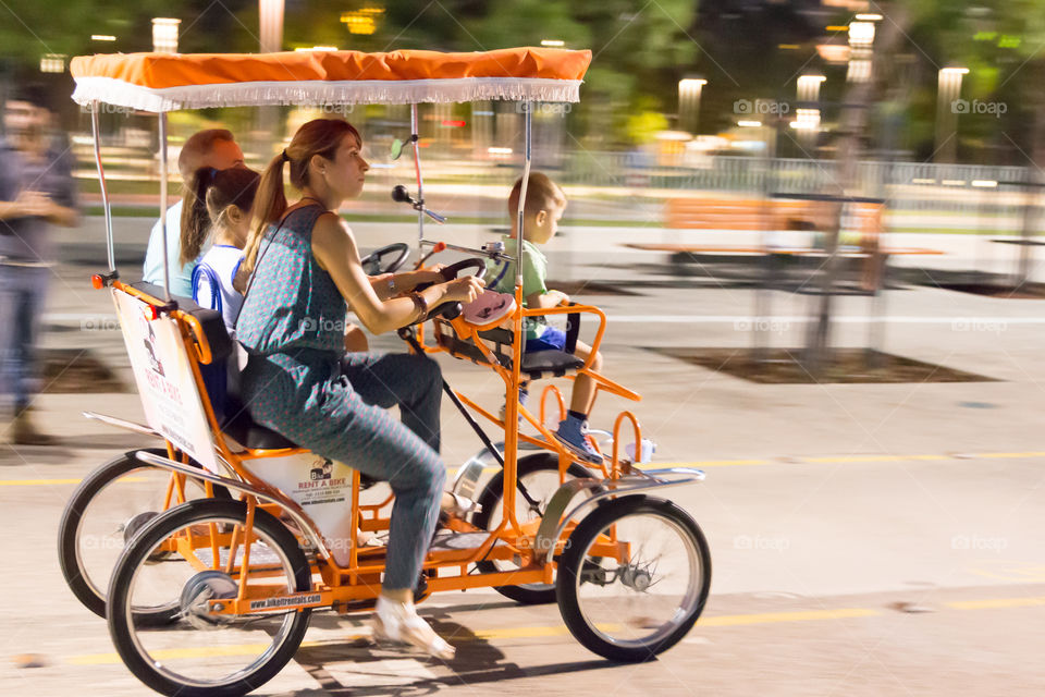 Family Ride In The City On Surrey Bicycle With Children Seat
