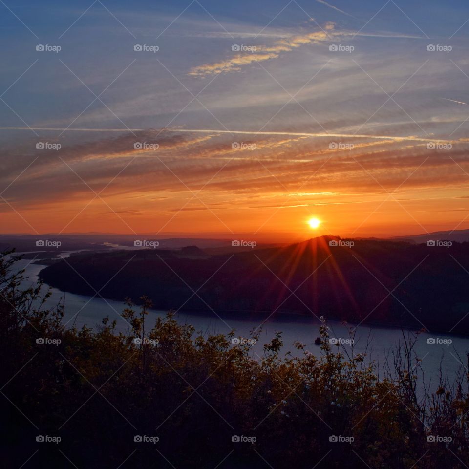 View of river against dramatic sky at dusk