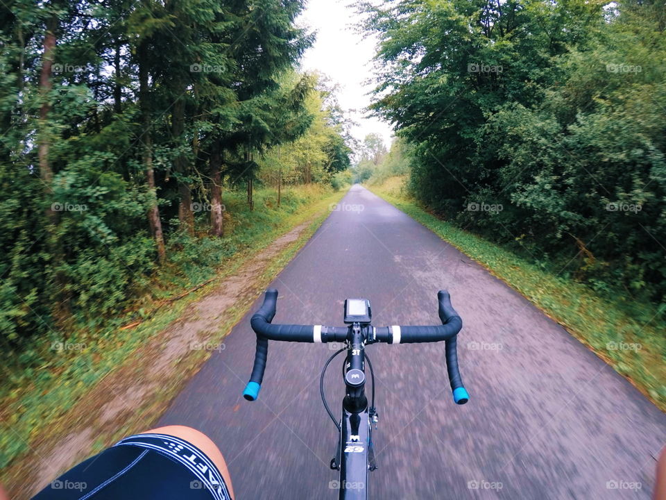 roadbike addicted. riding in the morning on a summerday. empty street. green around me.