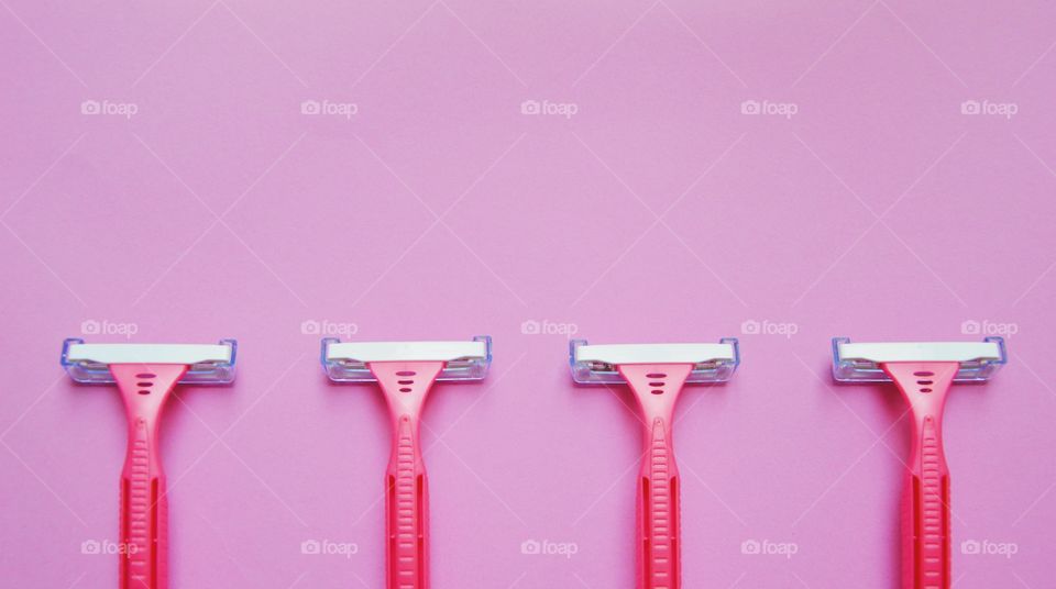 Flat lay of pink razors pr shavers