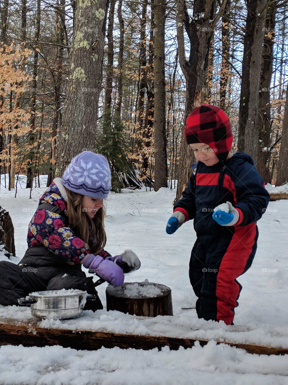 kids playing kitchen in the snow