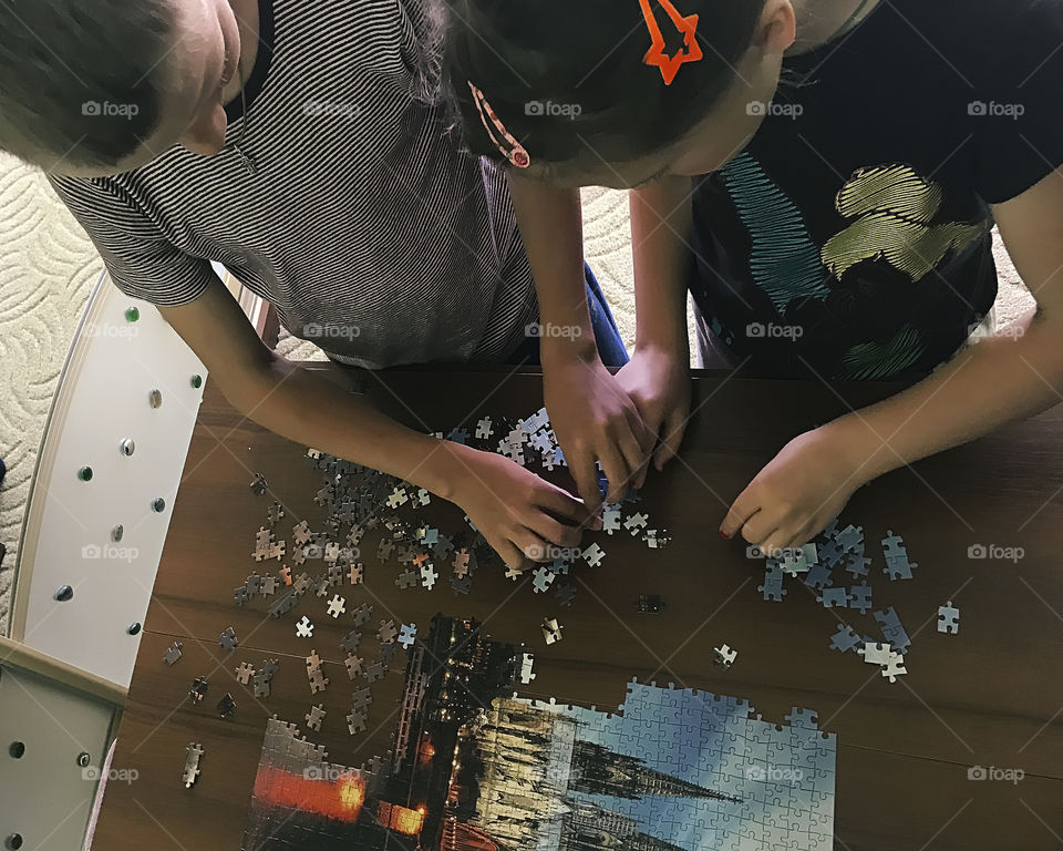 Kids gathering puzzles together at home 