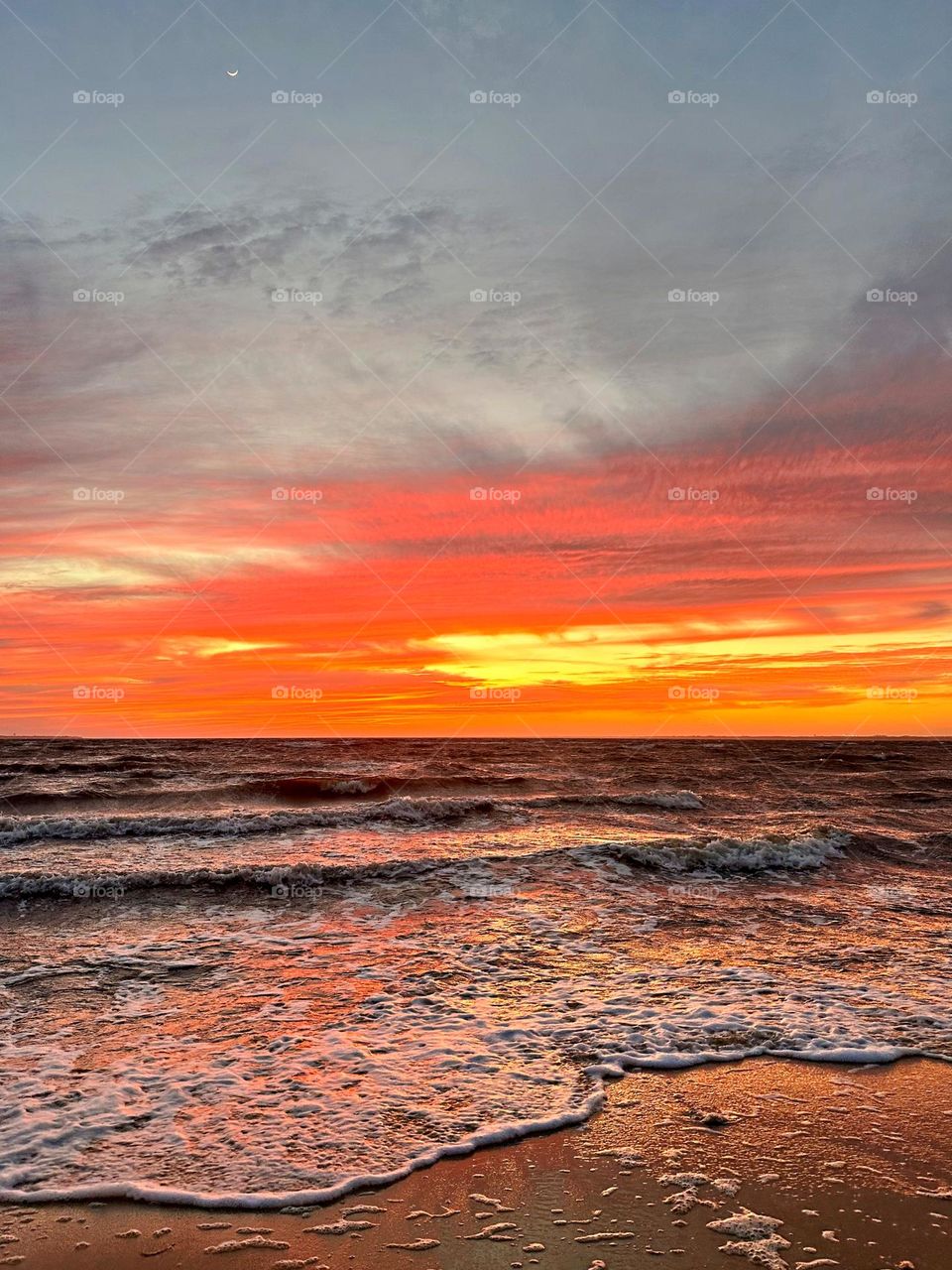 A breathtaking and radiant sunset which colors the waves iridescent, often towers and collides the shore with great force. The impact of the waves against the coastline created a stunning display of energy and motion