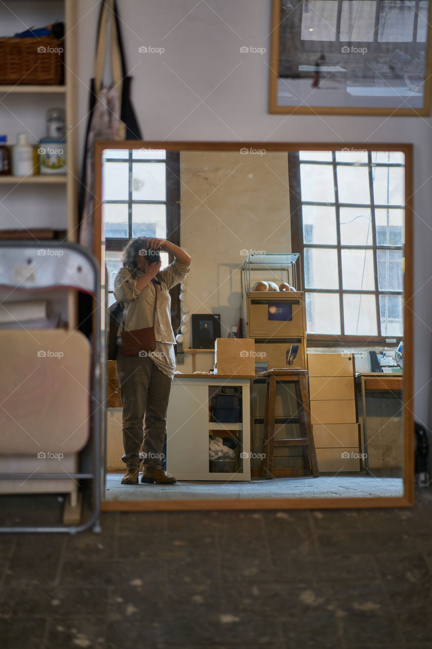 Woman taking photograph with camera reflecting on mirror