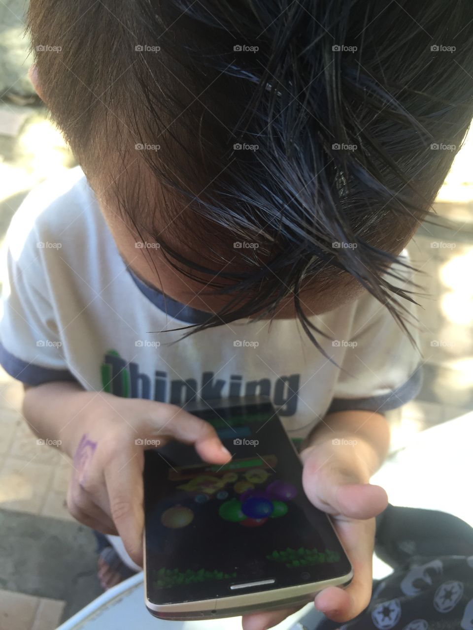 A little boy playing with phone