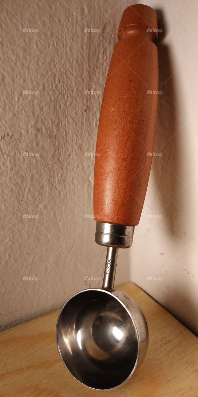 This image shows a tool for making ice cream portions. The photo was taken with a mobile phone, experimenting with the use of light and lens exposure.