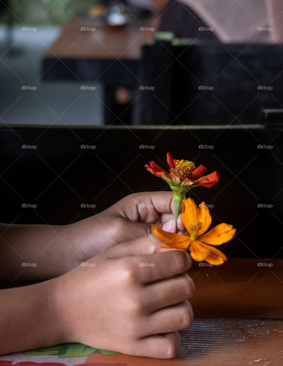 a child holds two flowers in hand