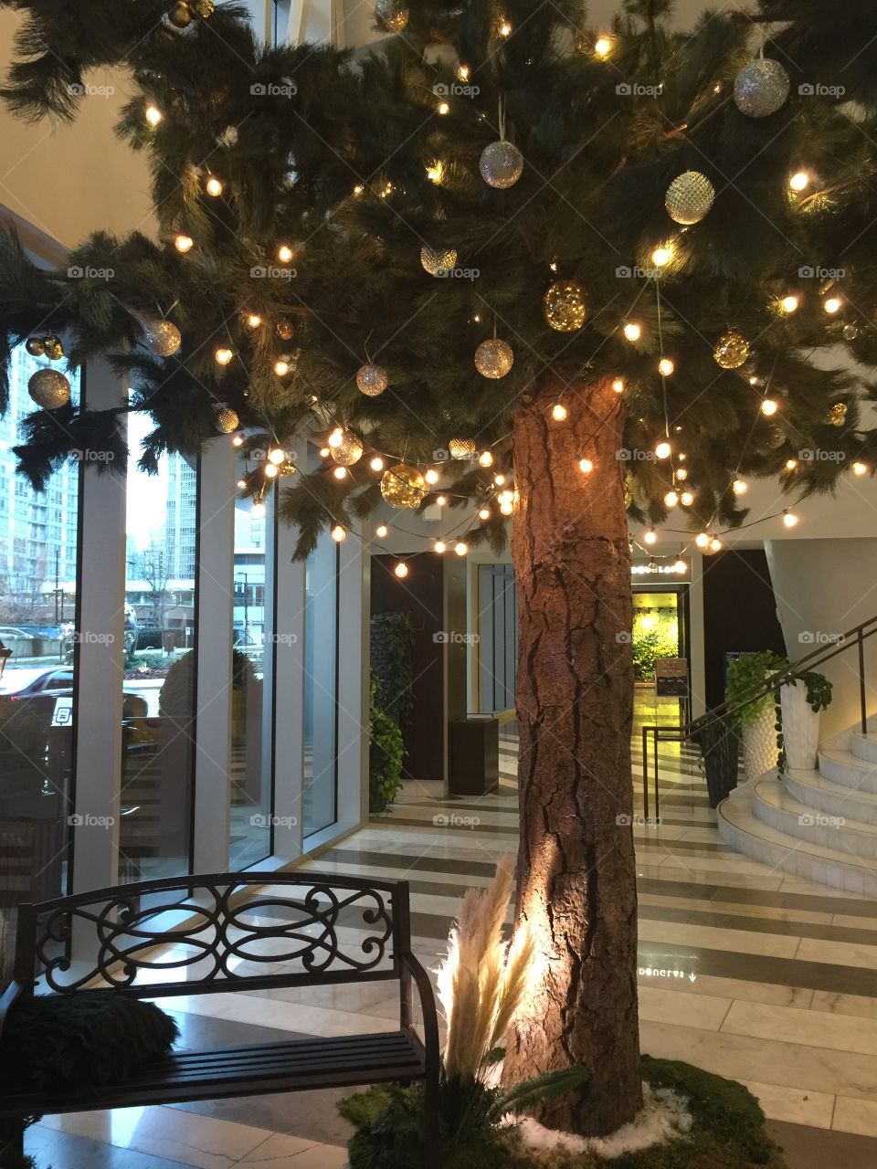 Christmas tree with bench inside lobby of hotel