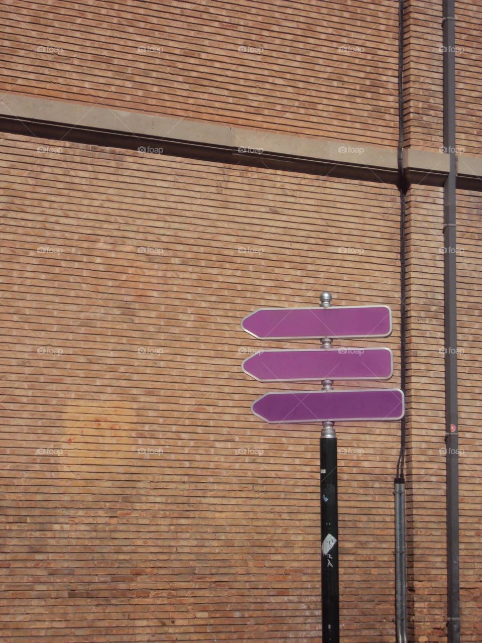 Brick wall and street sign arrows