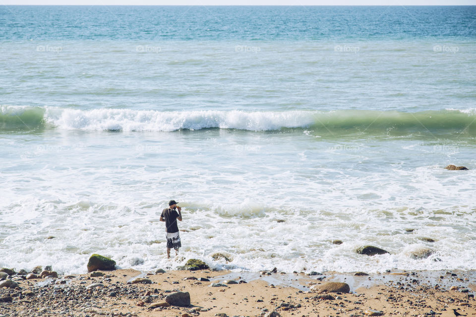 man standing beside big waves