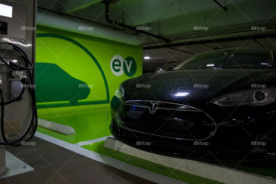 Tesla parked next to a charging station