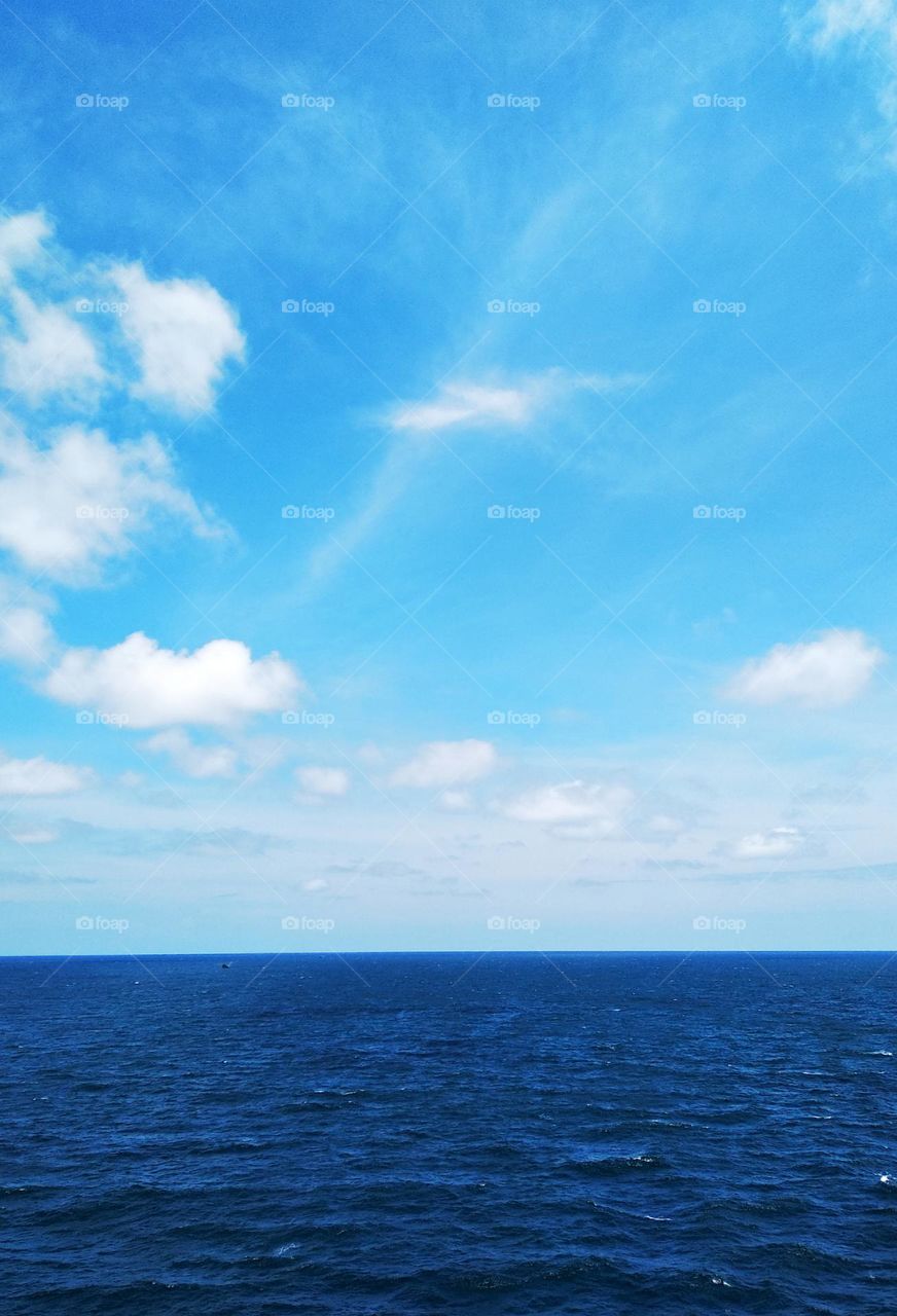 Cloudscape on the sea, "a bird" cirrostratus among cumulus clouds.