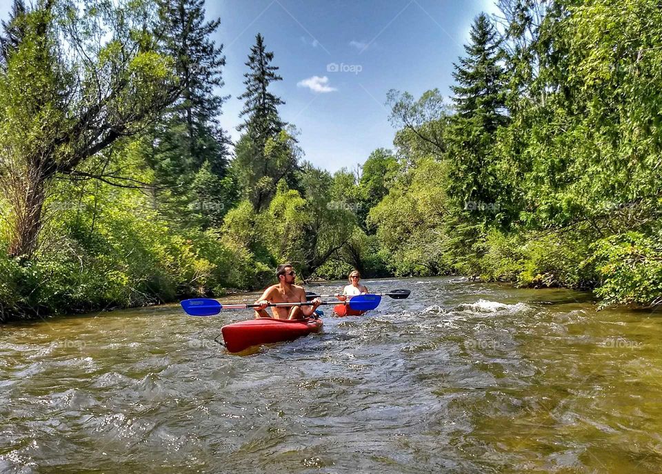 couple kayaking river in the woods