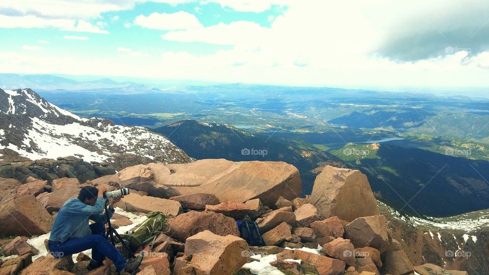 Photographer. Doing what he loves on top of the world.