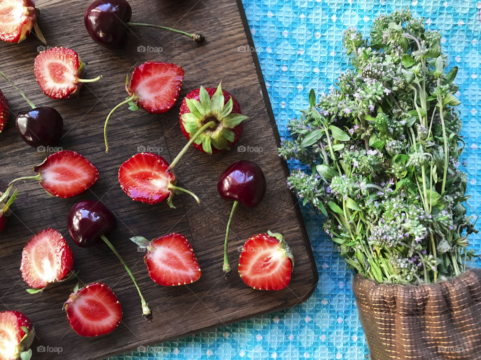 Strawberries, cherries and lavender plants on blue background 