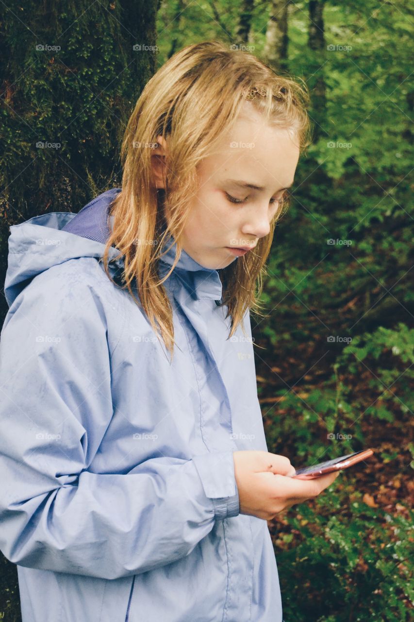 Girl uses her phone a rainy day