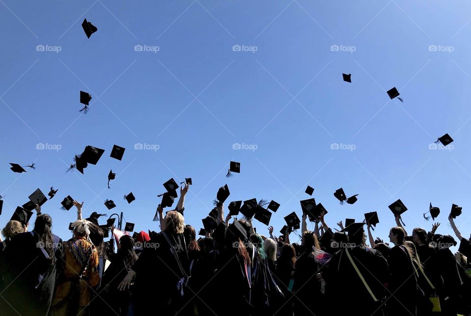 College graduation ceremony throwing hats