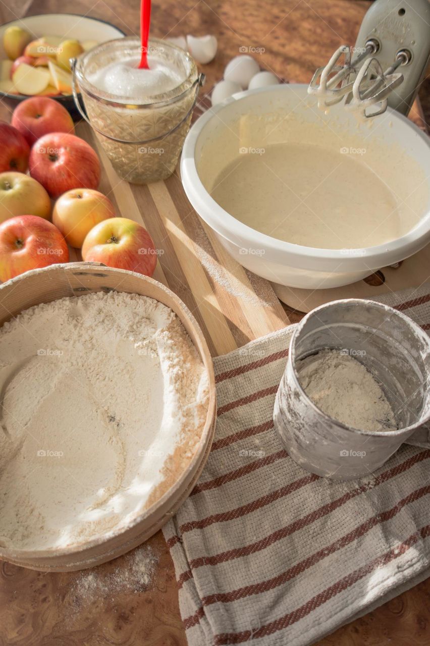 Making an apple pie dough using eggs, flour, sugar and apples.