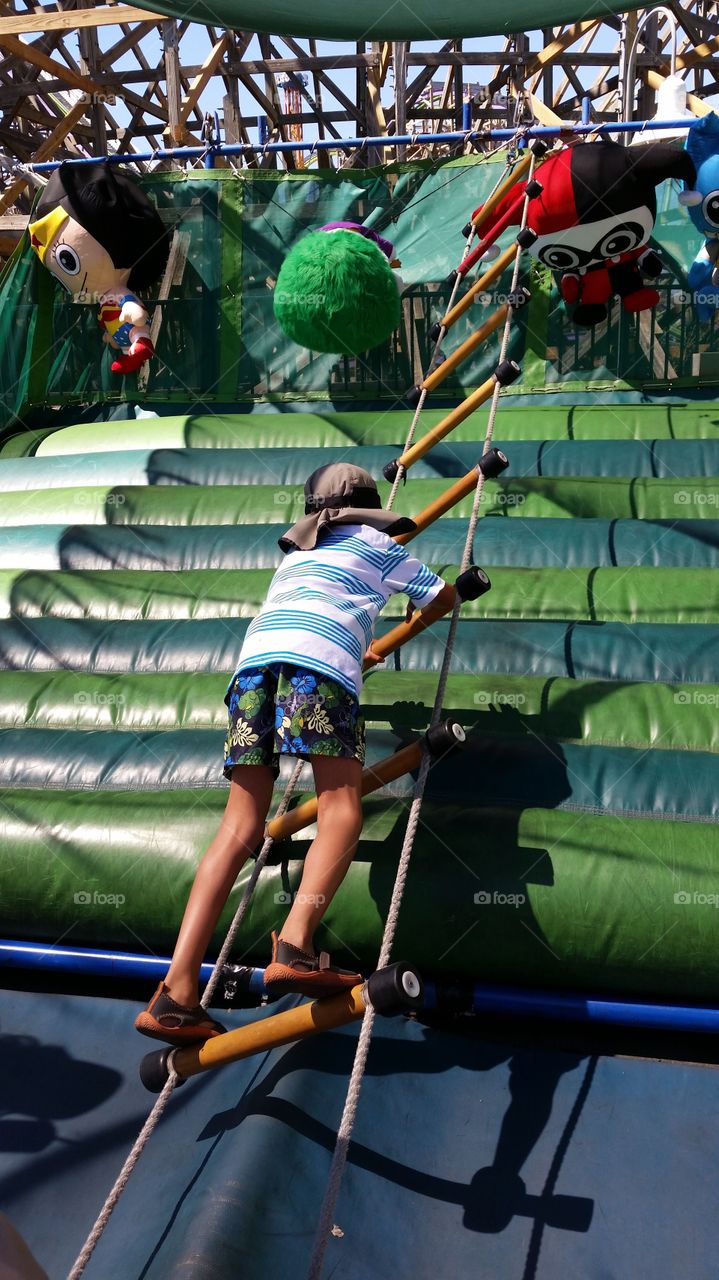 Having fun. Climbing a ladder on an obstacle course.