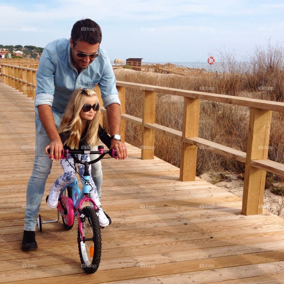 Dad teaching daughter to bike ride 