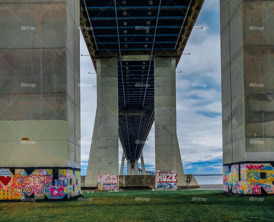 Graffiti covers the base of the pillars supporting Ponte Vasco da Gama