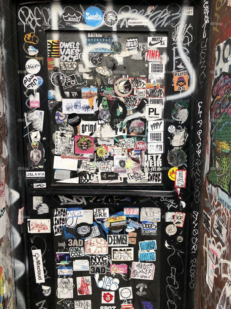 Sticker bomb on a New York door, classic New York Graffiti. Awesome fine that will keep evolving as people keep adding and removing their little pieces of art. 