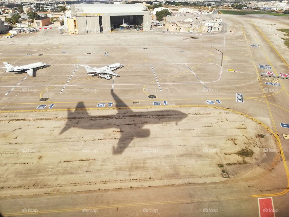 Aircraft on the runway and shadow of plane that is landing