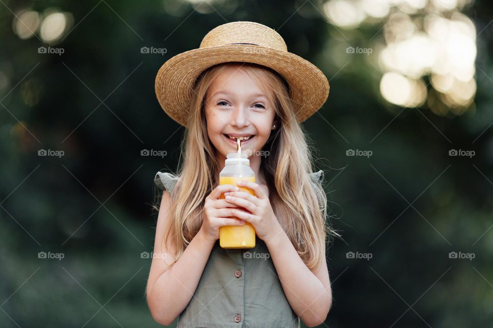 Happy blonde girl drinking juice 