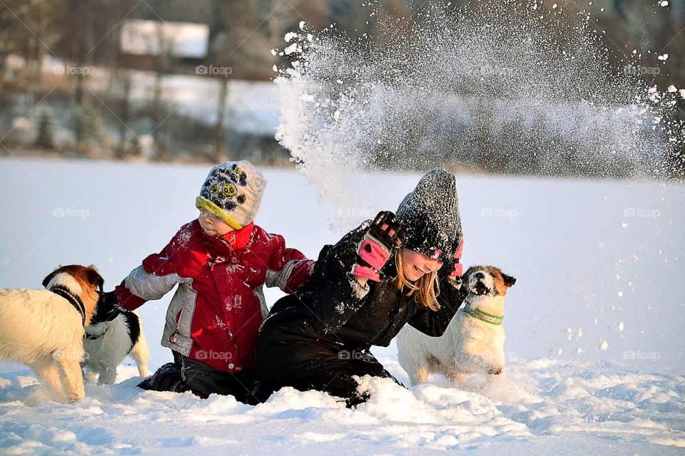 Children's playing in snow with dog