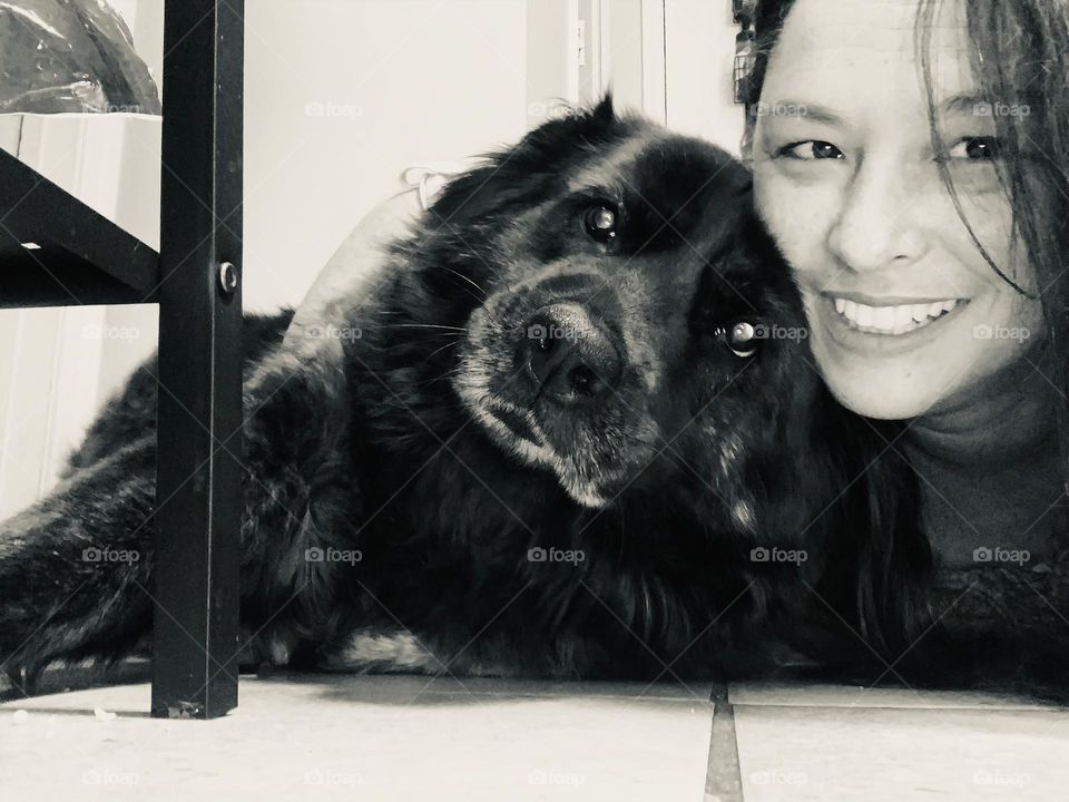 Photo selfie with mobile phone photograph of woman with friend pet dog on the floor happy in black and white.