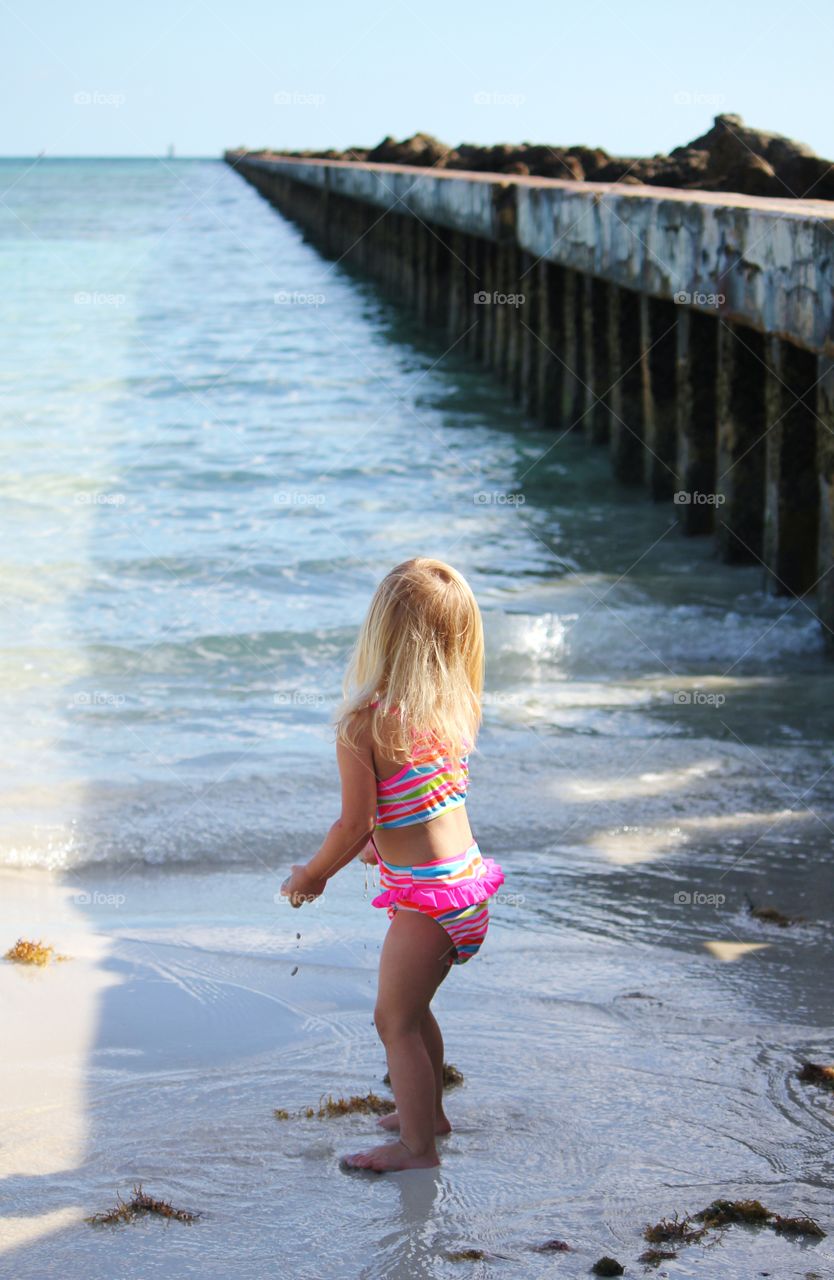 Small child staring into the ocean