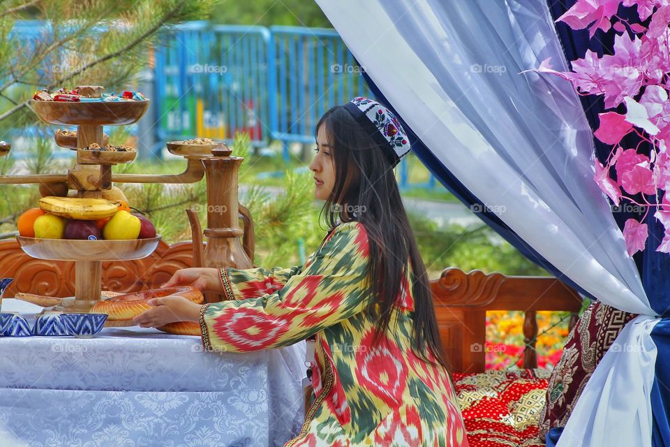 independence day in Uzbekistan. On the day of the holiday, people honor traditions by dressing up in national costumes and organizing fairs with performances.  in the photo of a girl in national festive  dresses.