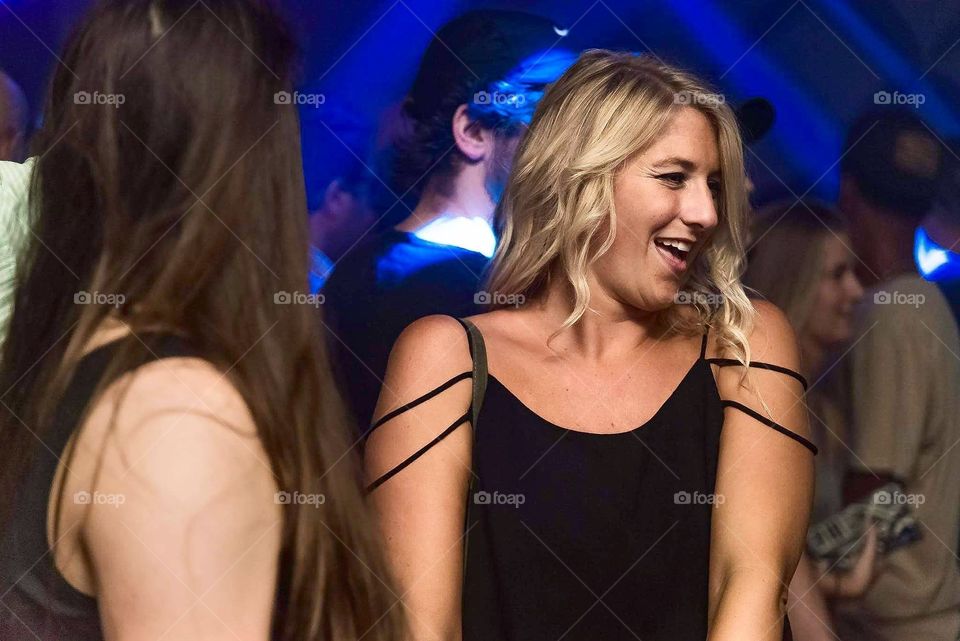 Girl having fun in a nightclub, lights flashing and smiling faces!