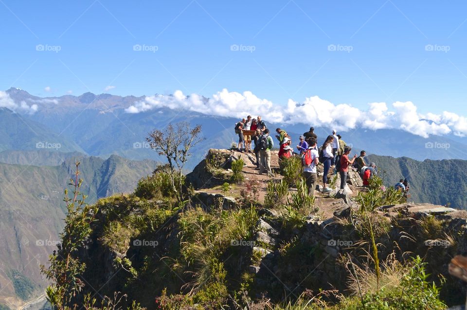 Travelers taking pictures next to Machu Picchu mountain altitude sign in Machu Picchu archaeological site area, Peru. 