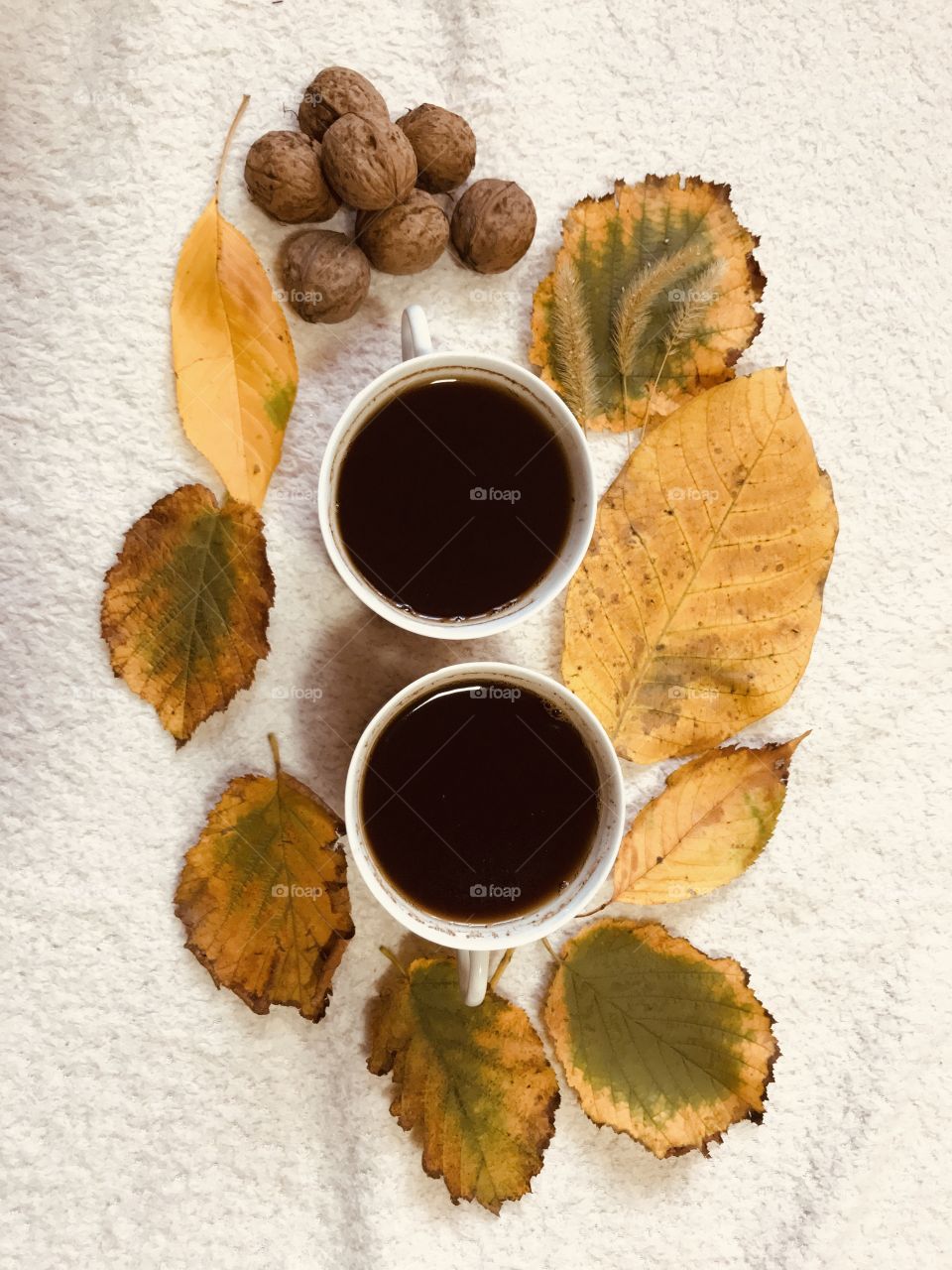 The two white cups of coffee in the autumn vibes.