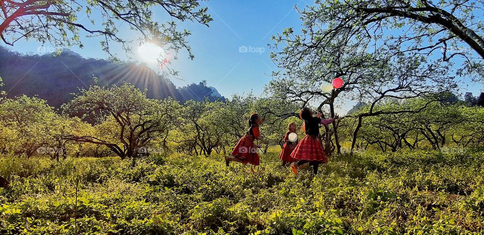 The baby girls playing with balloons in the garden