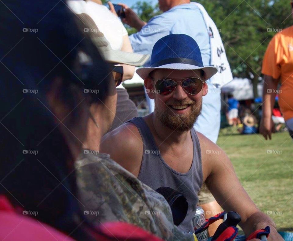 A man smiling while enjoying an outdoor festival