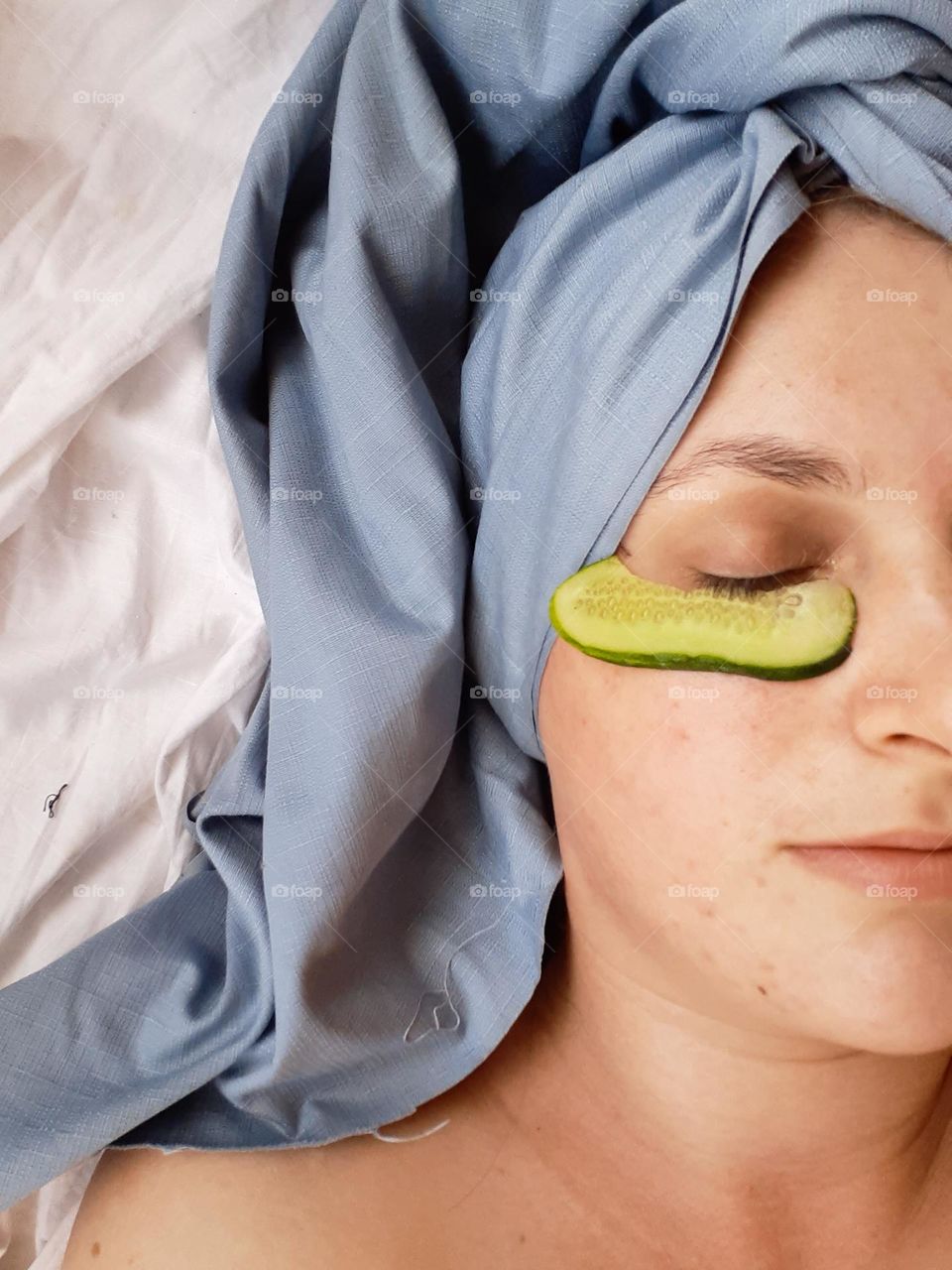 the girl relaxes during homemade cosmetic procedures, namely cucumber masks