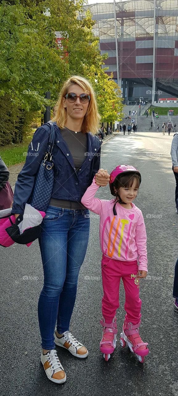 Smiling mother holding her daughters hand
