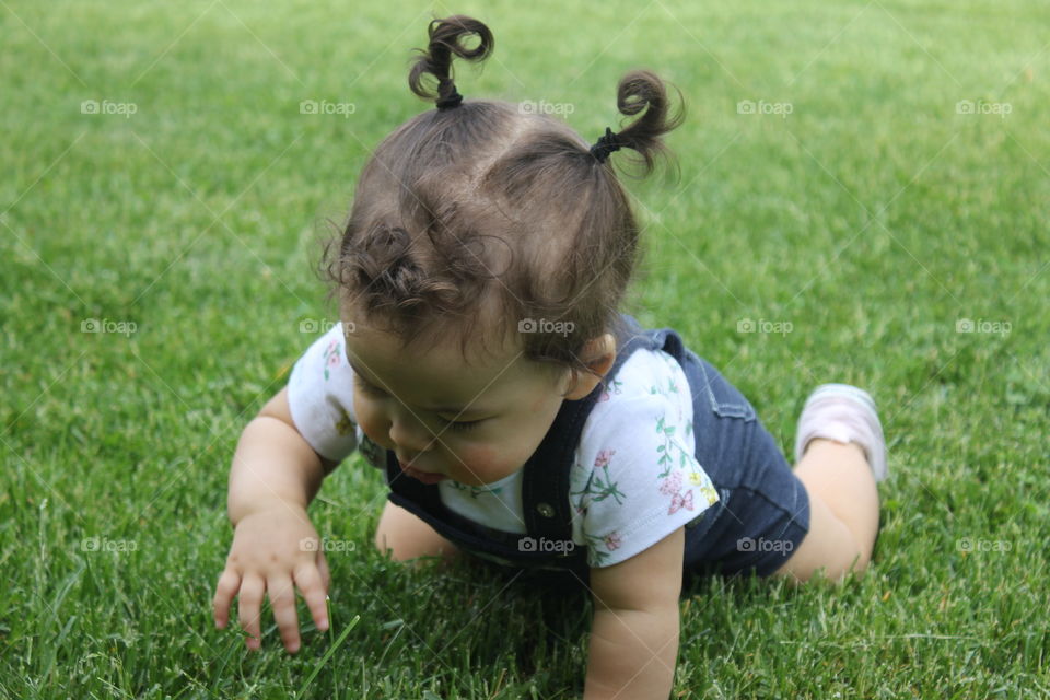 Baby crawling on green grass