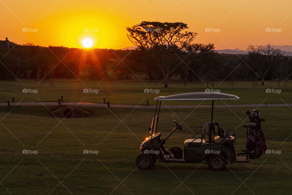 Golf cart with a colorful sunset in the back ground