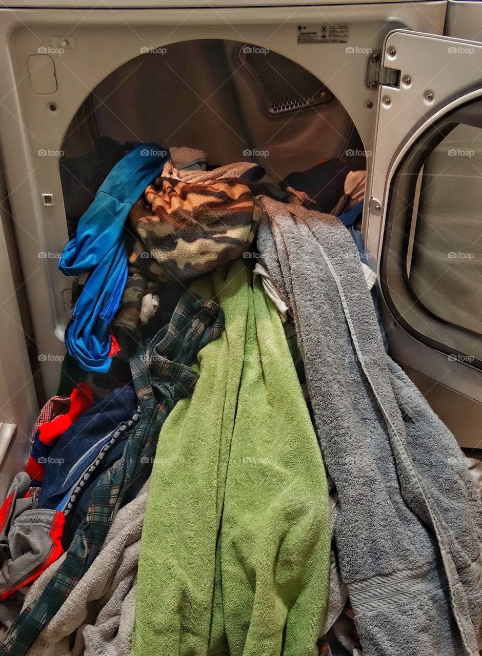 Too Much Laundry. Laundry Spilling Out Of A Clothes Dryer