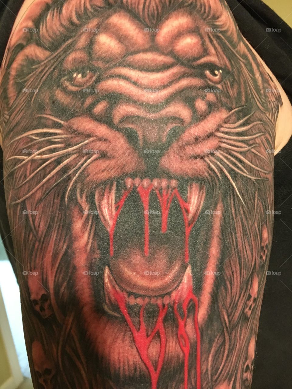 Lion head tattoo upper arm