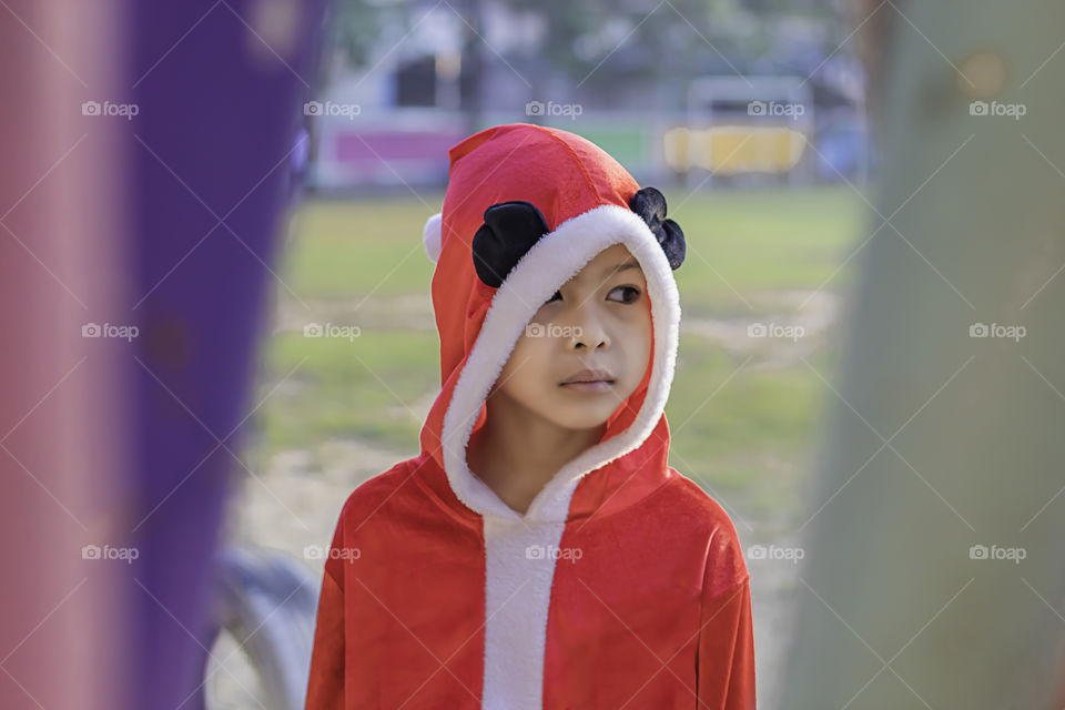 Asia boy wearing a red Christmas Background on the school lawn.